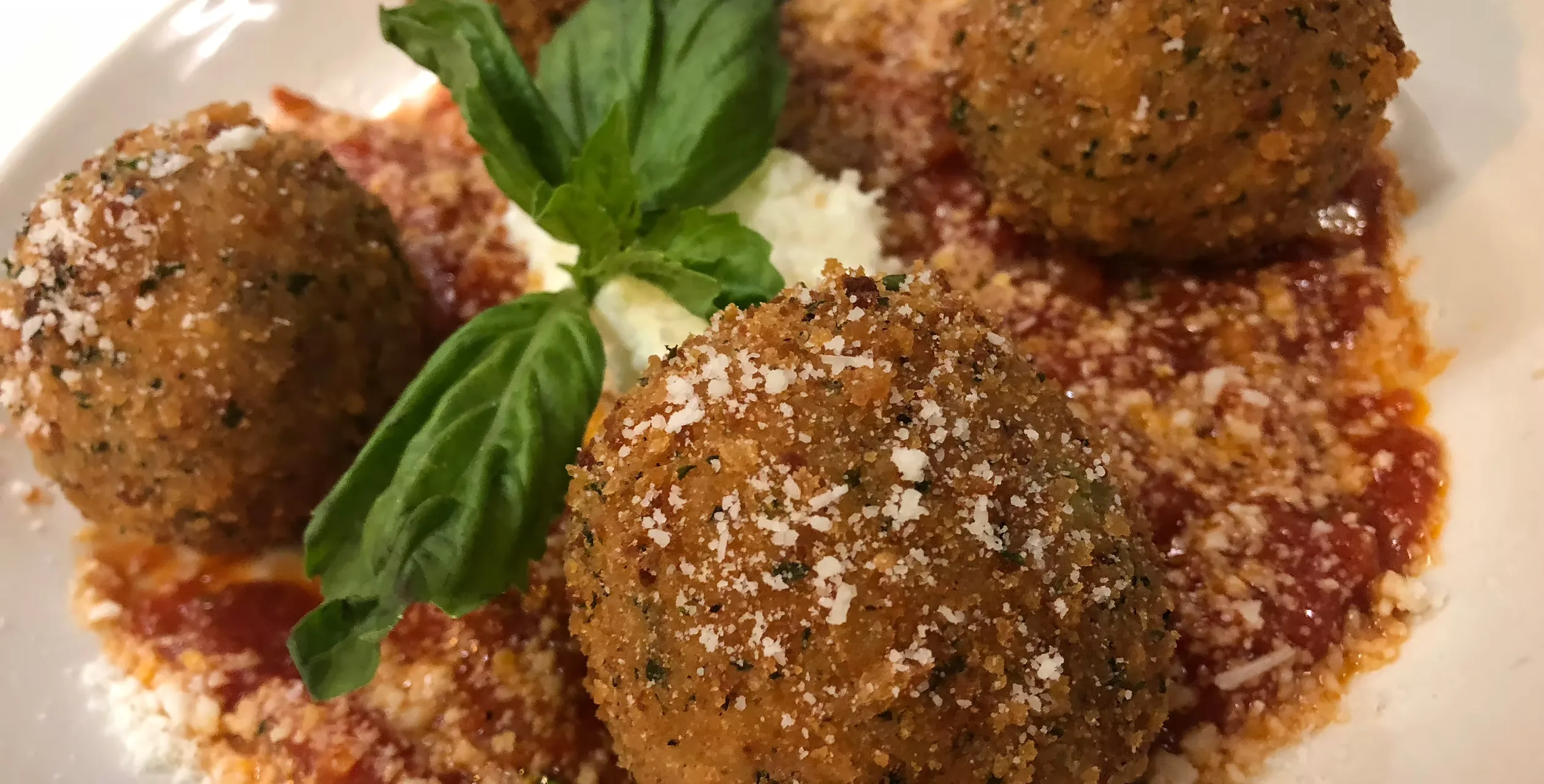 Breaded rice balls with tomato sauce and basil